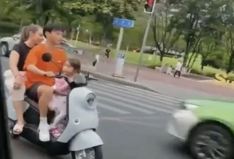 呼叫谭警官？中超球员一家3口骑电动车行驶在马路中间 全没戴头盔相关图二